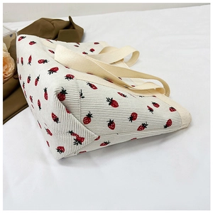 Detail of strawberry print corduroy tote bag showing thick fabric texture and base stitching