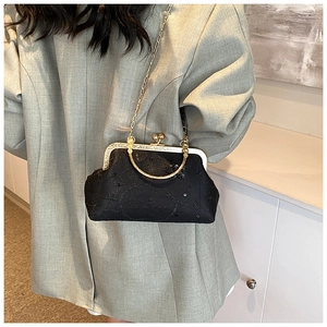 Détail du sac vintage noir avec broderies étoiles, paillettes et bandoulière chaîne dorée