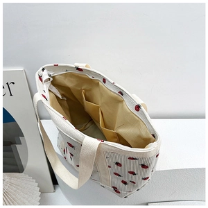 Detail view of corduroy tote bag interior featuring double slip pockets and zipper closure