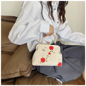 Détail du sac en paille tissé à la main avec broderies rouges et fermoir doré