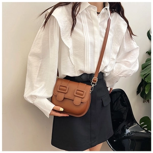 Sacoche marron rétro en cuir avec chemise à volants blanche et jupe noire à taille haute