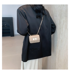 Borsa beige a tracolla trapuntata indossata da una modella con giacca e gonna