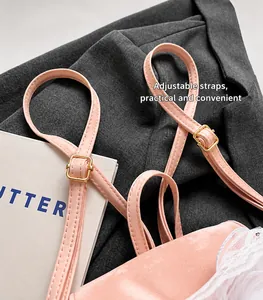 Detail of adjustable pink silk strap with gold buckle and delicate white lace trim