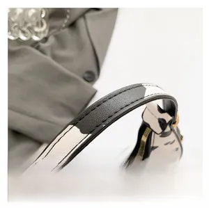 Close-up of zebra pattern handbag showing fine stitching and gold metal zipper detail
