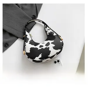 Close-up showing the interior capacity of the leopard moon bag next to a smartphone