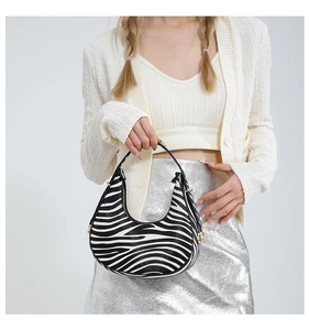 Close-up of zebra print hobo bag with sleek black handle and gold zipper detail