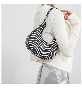 Close-up of zebra print crescent shoulder bag with textured leather and silver accents