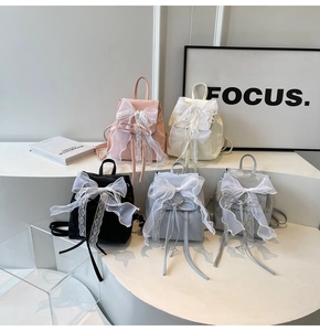 Close-up of stylish mini backpacks with lace bow accents in five pastel colors