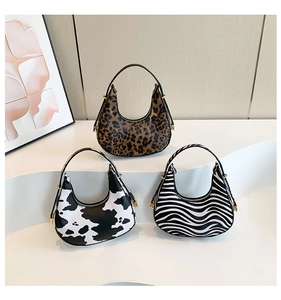 Three stylish half-moon hobo bags featuring leopard, cow, and zebra patterns on display