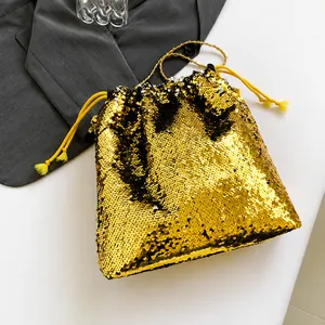 Detailed view of the gold sequin drawstring closure and decorative yellow tassels