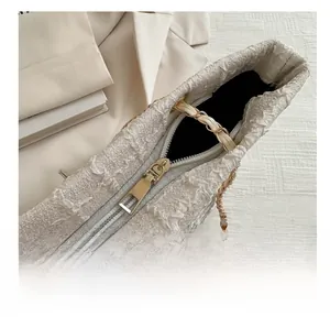 Detail showing the smooth golden zipper closure and woven texture of this large shoulder bag