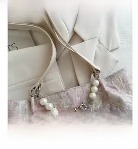 Detail of floral jacquard tote featuring large pearls and silver flower pendant charms