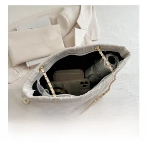 Interior view of textured cream tote bag showing capacity for phone, wallet and umbrella