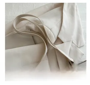 Detail of floral embroidery on tote bag with pearl accents and white faux leather handles