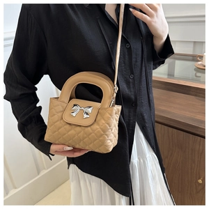 Detailopname van kaki gewatteerde crossbodytas met zilveren strik en verstelbare riem