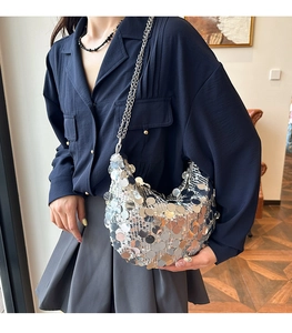 Detailed view of silver sequin hobo bag on model with elegant metal chain strap