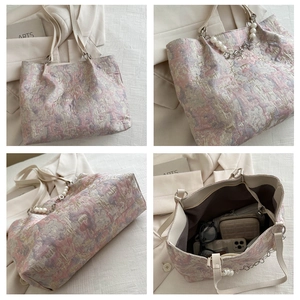 Macro view of jacquard fabric tote featuring pearl chain handle and spacious interior
