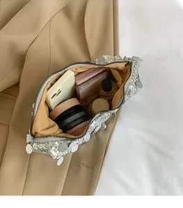 Interior view of silver sequin crossbody bag showing capacity for phone and cosmetics