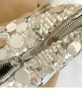 Detail of silver sequin handbag featuring smooth metallic zipper and high-quality hardware