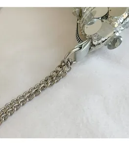 Macro shot of silver sequins and durable metal chain buckle on the stylish shoulder bag
