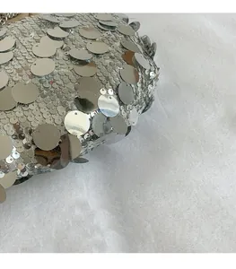 Detailed close-up of layered silver metallic sequins on a stylish crossbody handbag