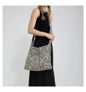 Detail view of stylish leopard print canvas tote bag with wide shoulder strap design