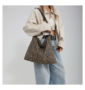 Detail of stylish leopard print canvas tote bag with matching wide shoulder strap for women