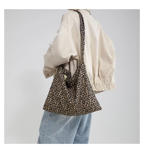 Detailed view of the leopard print canvas tote bag carried over a woman's shoulder