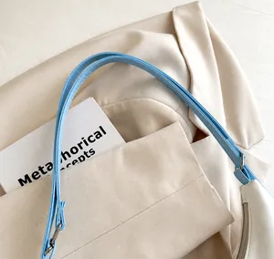 Detalle de la correa de cuero PU azul claro y herrajes plateados de un bolso de hombro