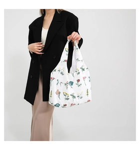 Détail d'un grand cabas à fleurs porté par un mannequin en blazer élégant et chic