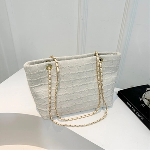 Elegant cream tweed bucket tote bag with gold chain straps and textured woven fabric