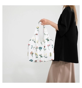 Vue détaillée du grand sac cabas en toile avec imprimés floraux vifs sur fond blanc