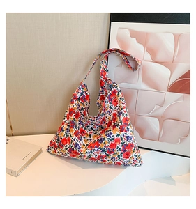 Detail shot of a large floral canvas tote bag on a white table in a cozy indoor setting