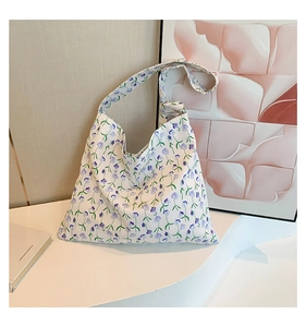 Detail of floral canvas tote bag with purple flower patterns and decorative knot strap