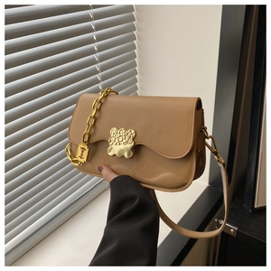 Détail du sac bandoulière kaki avec boucle dorée irrégulière et bandoulière en chaîne
