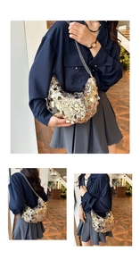 Detailed view of fashionable sequined half-moon underarm bag with metal chain strap