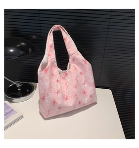 Détail d'un sac cabas en toile rose à fleurs avec motifs tulipes dans un décor intérieur