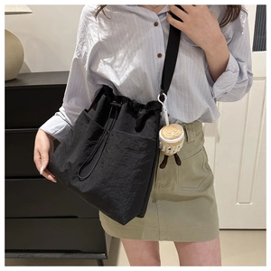 Black nylon bucket tote bag with drawstring closure and cute latte art plush charm