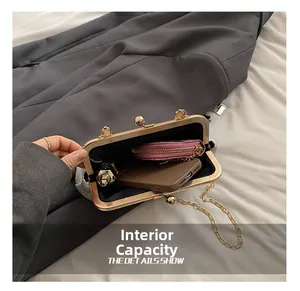 Detail showing the internal capacity of the cream crossbody bag with gold chain strap