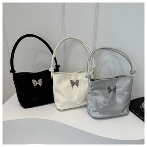 Detalle de bolsos tipo cubo de tela vintage con hebillas de mariposa en tres colores