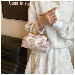 Détail du sac en satin crème avec broderie papillon rose et fermoir doré chic