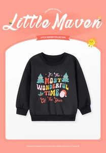 Close-up of black Christmas sweatshirt featuring festive text and holiday tree graphics
