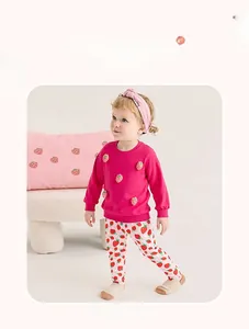 Détail d'un ensemble en coton pour fille avec broderie fraise et legging assorti