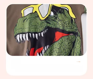 Gros plan d'un imprimé dinosaure de dessin animé avec lunettes sur un T-shirt marron