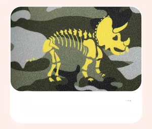 Détail du tissu camouflage garçon avec imprimé squelette de dinosaure jaune et tricot