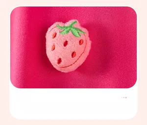 Détail d'applique fraise 3D en peluche avec broderie sur tissu en maille rose
