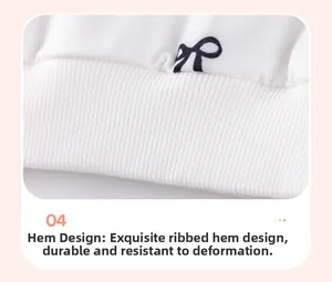 Detailed view of the wide ribbed hem on a girls cotton long sleeve top with bow print