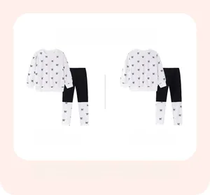Flat lay view of girls' long sleeve pajamas set with black bow print and colorblock leggings