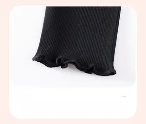 Gros plan du legging côtelé noir pour fille avec ourlets ondulés à bordure laitue