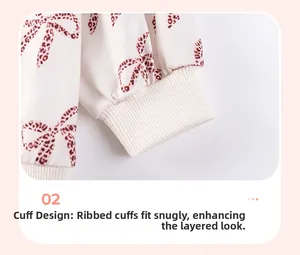 Detail of ribbed knit cuffs on girls' long sleeve top with brown leopard bow print